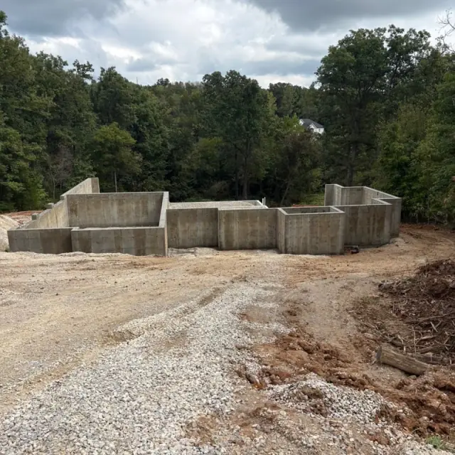 Finished foundation walls stepping across a cleared lot
