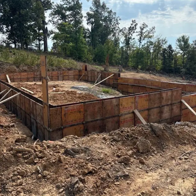 Steel wall forms braced around a basement dig on a hillside